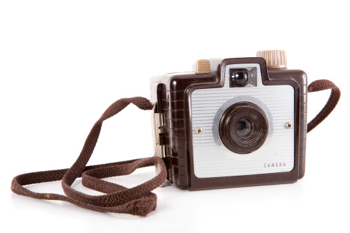 A small retro point-and-shoot camera with strap, isolated on white.