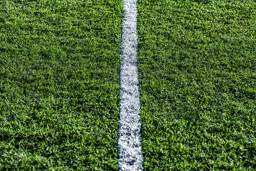 A single white sports chalk line on green grass.