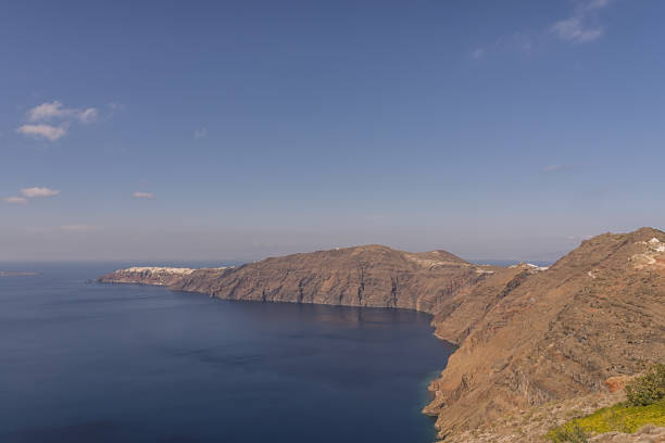 View of Santorini cliffs surrounded by blue ocean, Greece