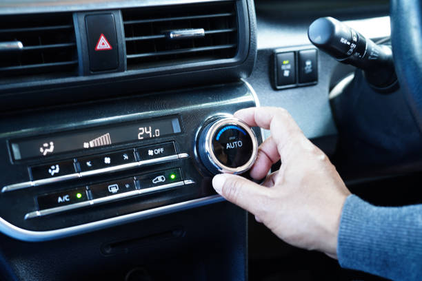 istock Asian woman driver tuning temperature control air condition system in car. 1448050683