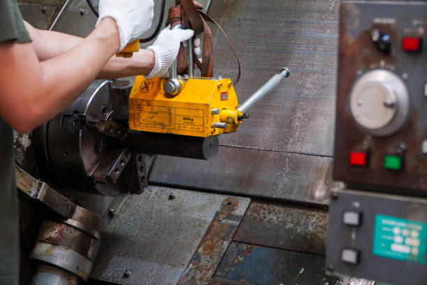 istock mechanic uses a magnet to lift the workpiece controlled by hand. 1448050726
