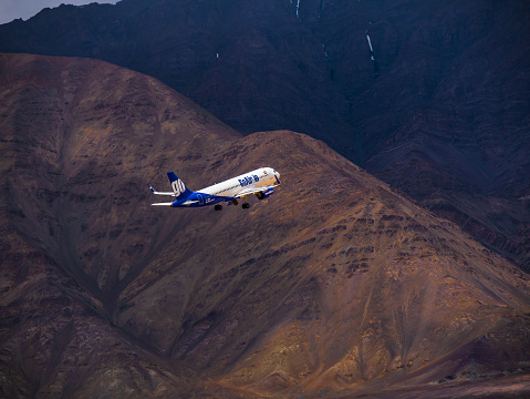 Ladakh, India - June 19, 2022 : Go Air, indian passenger plane fly up from Leh airport surrounded by Himalaya mountain range