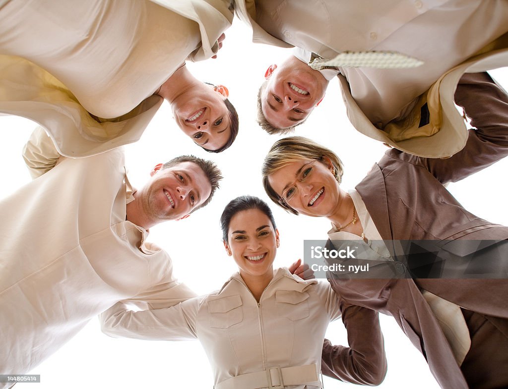 Happy Team Five busines people huddle, directly below view. Beige Stock Photo