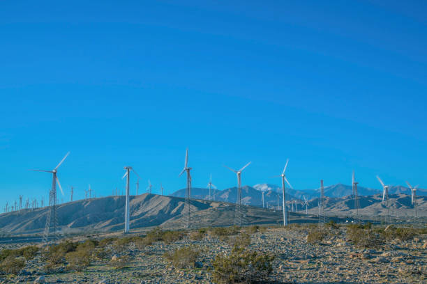 istock Windmills renewable energy generator againts blue sky background 1448058018