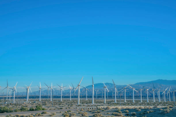 istock Windmills on a sunny day landscape with mountains and blue sky background 1448058873