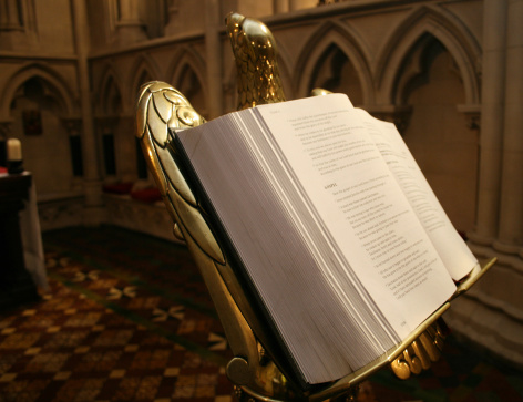 open bible on antique golden stand in medieval church in Ireland. Bible open on gospels
