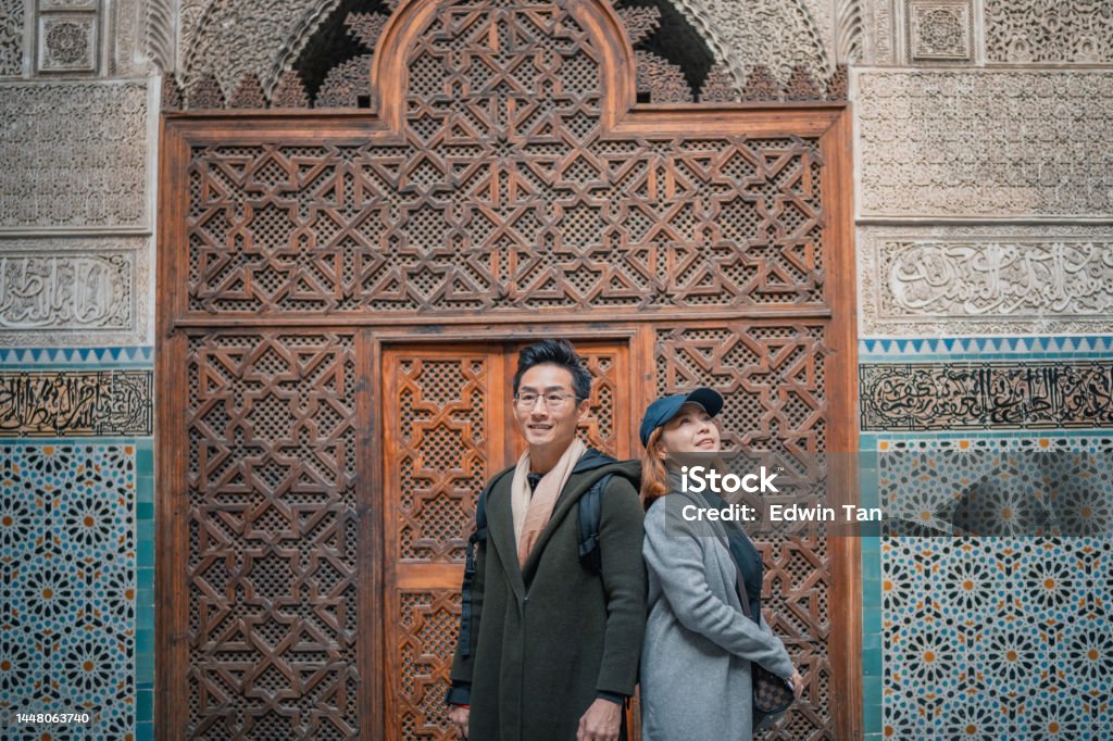 portrait Asian Chinese tourist couple standing at Fez Mosque Bou Inania Madressa Admiration Stock Photo
