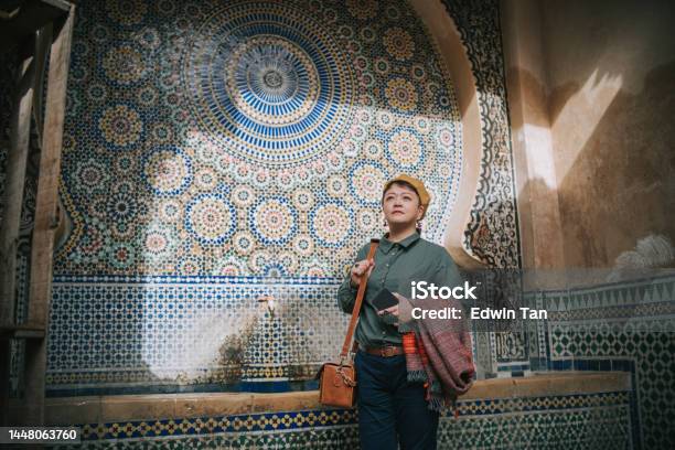 Asian Chinese Female Tourist Resting At Public Drinking Fountain In The Old City Of Fez Fes Morocco Stock Photo - Download Image Now