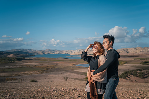 Asian Chinese man hugging wife enjoying breeze moment at beautiful nature landscape near Fez, Morocco