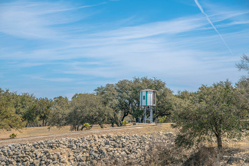 Watch tower against trees and blue sky on a sunny day in Lake Austin Texas. Outdoor landscape near a lake with a small building construction designed for watching the surrounding area.