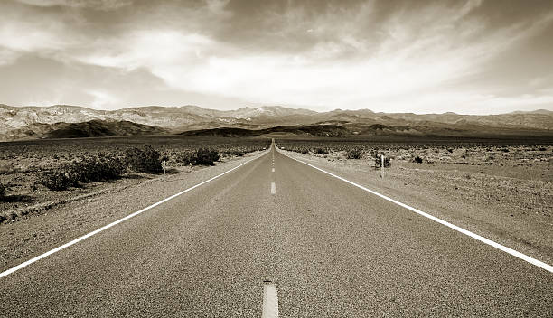 Black and white photo of highway through desert