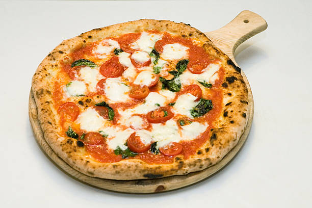 Pizza on a wood dish white background stock photo