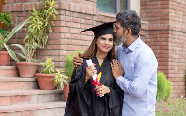 Indian university female student and her father celebrating graduation degree convocation ceremony