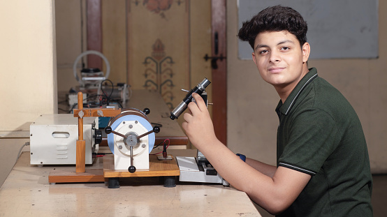 Indian male student working or experimenting in science lab.