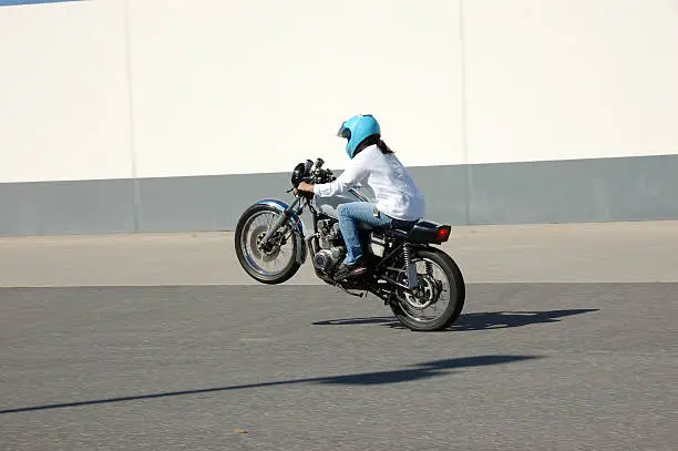 girl doing a wheelie on motorcycle