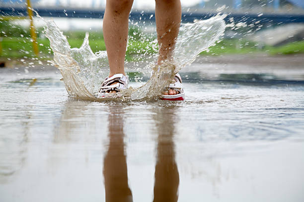 istock Person splashing in puddle with shoes 144807095