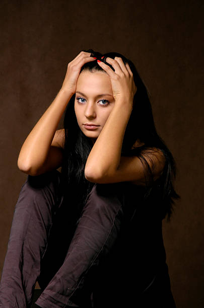 The sad beautiful girl on a dark background stock photo