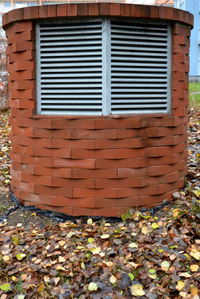 cube-shaped ventilation grid boxes. slats cover the air recovery ventilation pipe of a residential building, energy passive building, subway tunnel ventilation. Heat pump, brick, lawn, brick, box