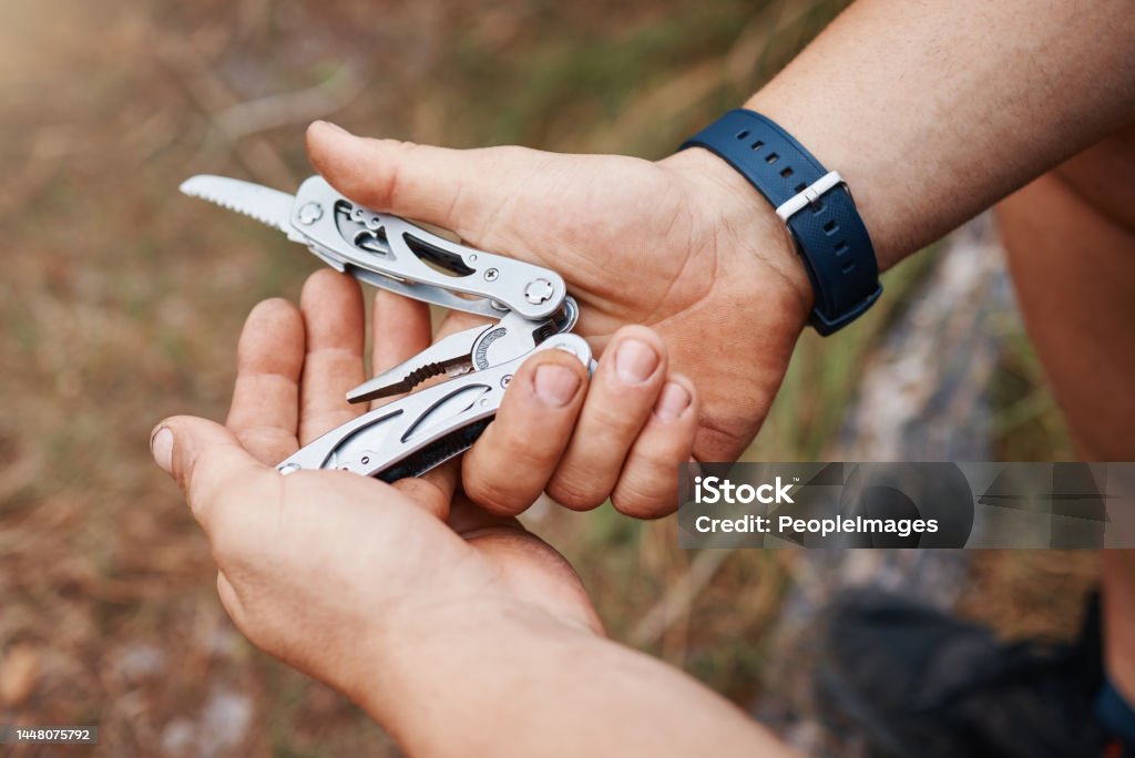 Hands, man or multi purpose knife in environment camping land, sustainability forest woods or hiking mountains. Zoom, hiker or swiss army blade, survival tools or metal equipment gear in nature earth Penknife Stock Photo