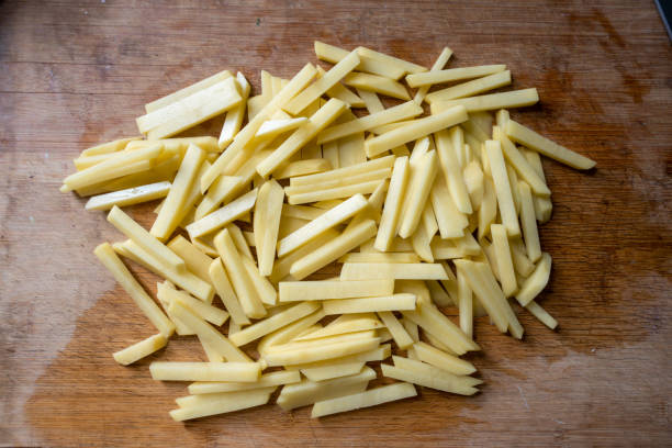 istock Sliced ​​fresh potatoes on wooden kitchen board 1448079041