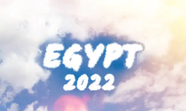 Photo of Egypt 2022. Travelling to Egypt by plane. Text from clouds in sky in bright sunlight.