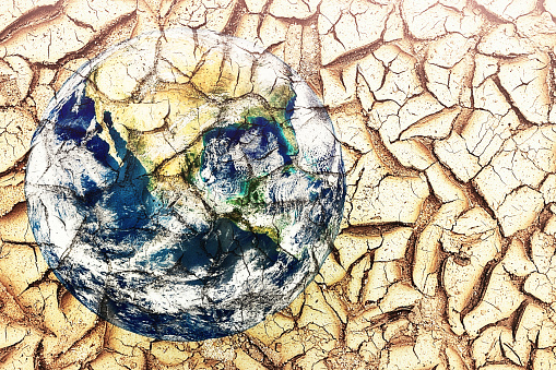 Planet Earth emerges from a cracked, dried-up lake bed in a drought. Public domain Earth image from https://www.nasa.gov/multimedia/imagegallery/image_feature_2159.html