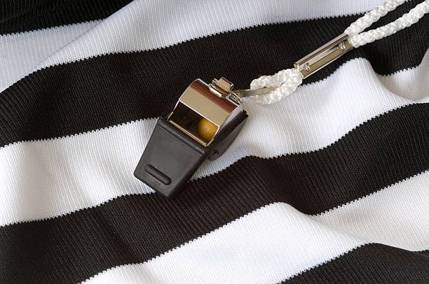 Whistle on a black and white striped referee shirt stock photo