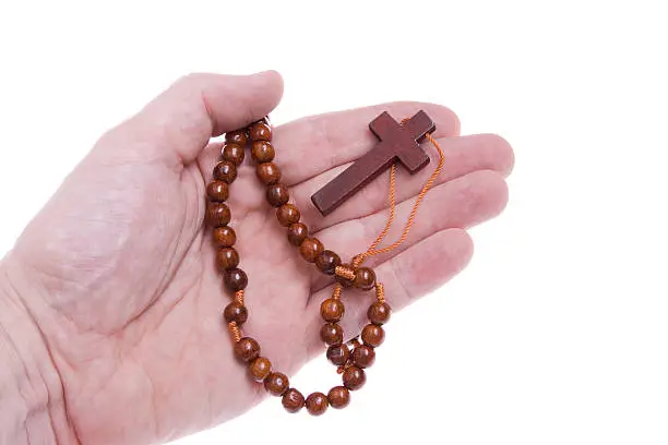 Photo of Hand Holding a Rosary Cross on Isolated White Background