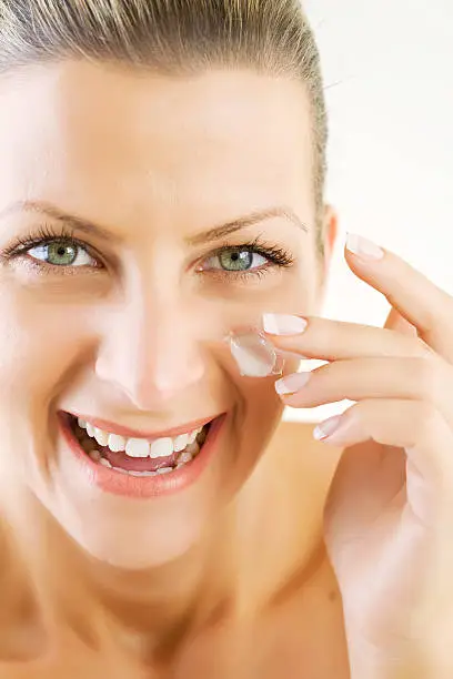 smiling young woman applying moisturizer