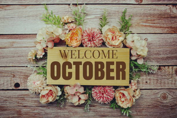 istock Welcome October text on wooden board with flowers frame on wooden background 1448087309