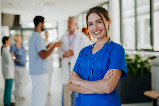 portrait of young woman nurse at hospital corridor. - 護士 個照片及圖片檔