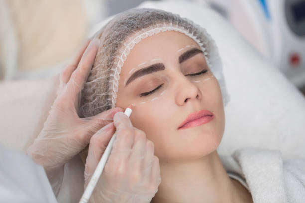 istock Plastic surgery concept. Hands in gloves marking women face 1448095052