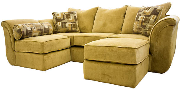 Dark beige sectional sofa with an ottoman and accent pillows stock photo