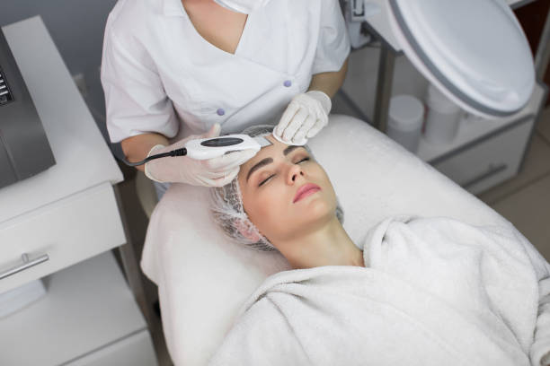 skin care. close-up of beautiful woman receiving ultrasound cavitation facial peeling. ultrasonic skin cleansing procedure. beauty treatment. cosmetology. beauty spa salon. - exfoliating scrub imagens e fotografias de stock