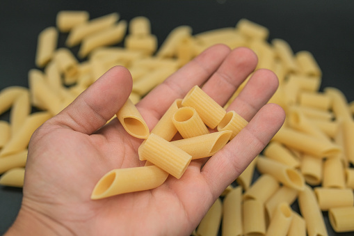 Fresh raw uncooked penne and maccaroni pasta,italian healthy kitchen food background.