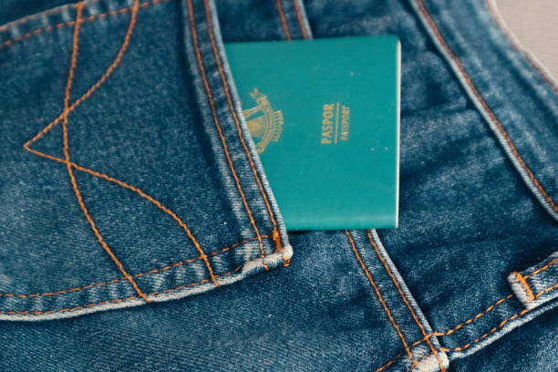 An Indonesian citizenship passport in a jeans pocket. An Indonesian citizenship passport in a jeans pocket. This photo is suitable as an illustration of traveling abroad. jeans denim passport pocket stock pictures, royalty-free photos & images