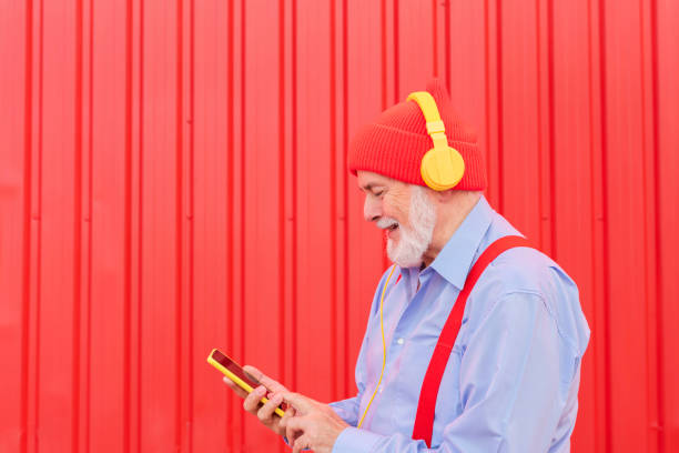 istock a modern retiree listening to music with headphones while using his mobile phone 1448097441