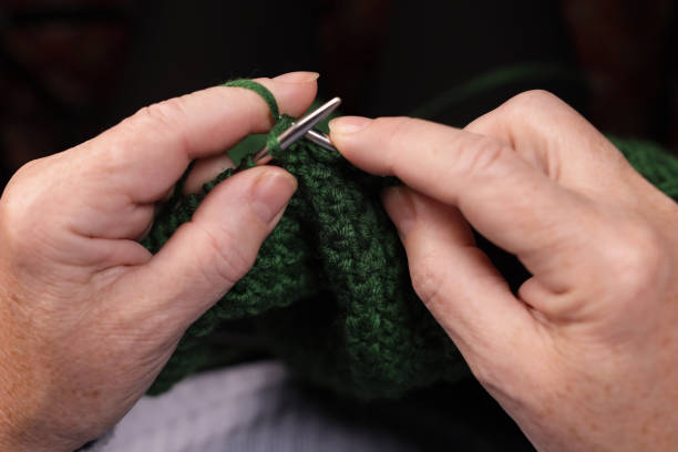 istock Woman hands knits with green threads close up. Handmade hobby knitting 1448099767
