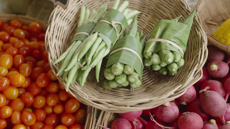 Various fruits and vegetable on bamboo weaving basket in a market stall.