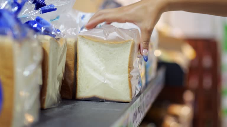 Sliced bread for toasts packed in individual plastic bags, woman pick one