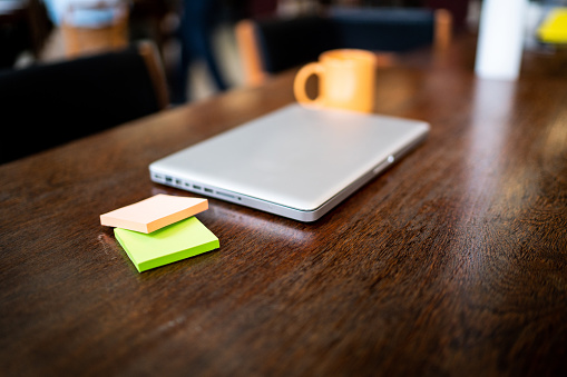 Laptop, mug and adhesive notes on the desk