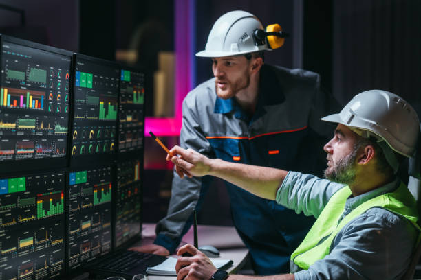 l’ingénieur en chef et l’ouvrier qui suivent la ligne de production de l’usine utilisent des écrans avec le logiciel industrie 4.0. quelques opérateurs d’installations vérifient et analysent le processus - protective suit photos photos et images de collection