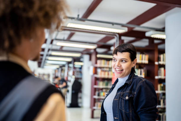 istock Friends talking in the library - including a transgender person 1448105492
