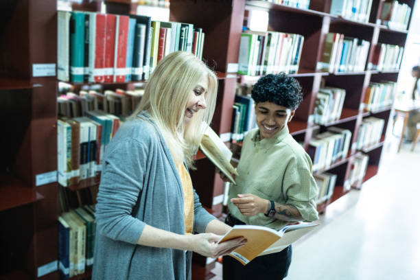 istock Friends talking and reading book in a library's corridor 1448106901