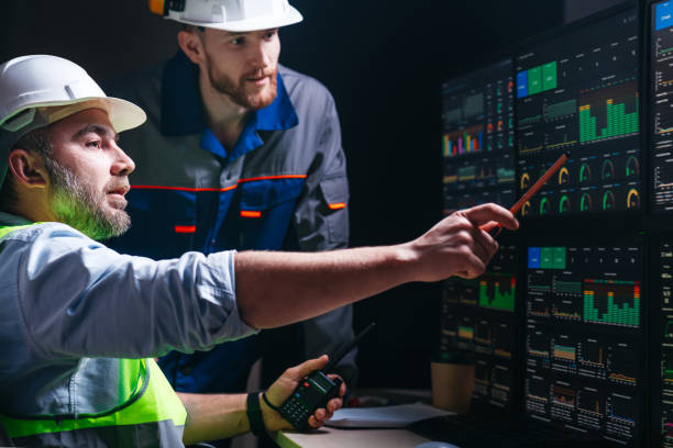istock Head engineer and factory operator following product process on factory uses SCADA system and industry 4.0. Two operators controll assembly line using screens with human-machine interface 1448106902