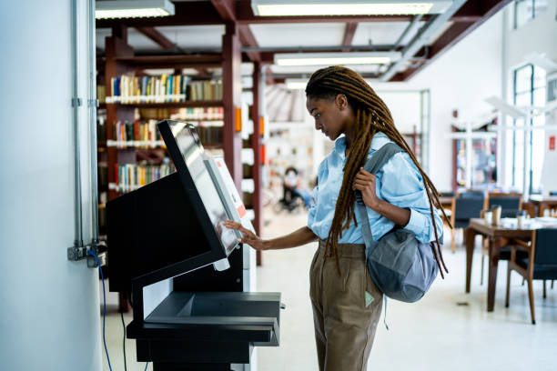 estudante à procura de um livro no sistema de bibliotecas - african ethnicity standing college student curly hair - fotografias e filmes do acervo