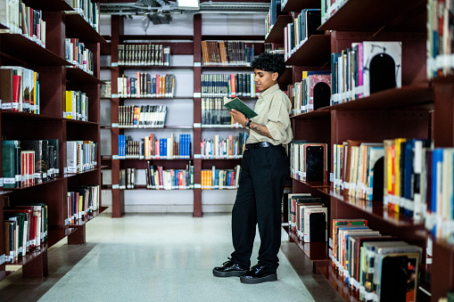 Young woman reading a book in a library