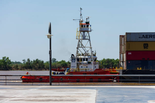 remorqueur nommé: « ava payagua », naviguant sous pavillon du paraguay, poussant une barge porte-conteneurs de la marine, dans le fleuve parana, descendant vers le fleuve. vue de la ville de rosario, santa fe, argentine. jour 23 novembre 2022. - named logistics company photos et images de collection