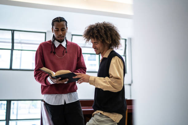 istock Friends talking holding book in a library 1448115612