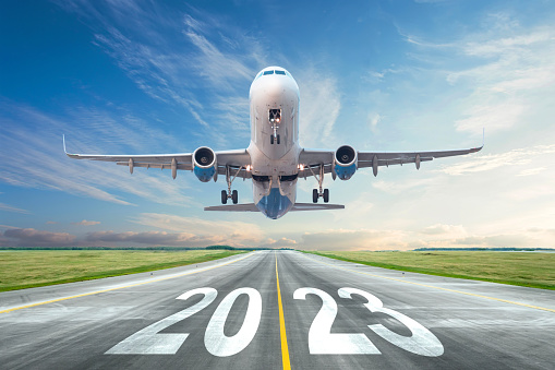 Inscription on the runway 2023 surface of the airport road yellow line take off airplane. Concept of travel in the new year, holidays